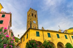 Katolsk kyrka av den San Giovanni Battista chiesaen med klockatornet, färgrika byggnadshus och blommor omkring i den Monterosso v arkivfoton Katolsk kyrka av den San Giovanni Battista chiesaen med klockatornet, färgrika byggnadshus och blommor omkring i den Monterosso v arkivfoton
