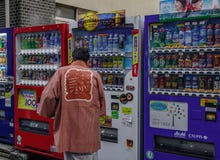 Kaufende Getränke eines Mannes am Automaten lizenzfreies stockbild Kaufende Getränke eines Mannes am Automaten lizenzfreies stockbild