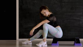 Kaukasisch brunette in sportkleding het stellen op camera, zwarte achtergrond stock videobeelden Kaukasisch brunette in sportkleding het stellen op camera, zwarte achtergrond stock videobeelden