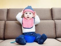Kaukasisches Baby weared den Schellfisch, der zu Hause auf Sofa sitzt stockfotos Kaukasisches Baby weared den Schellfisch, der zu Hause auf Sofa sitzt stockfotos