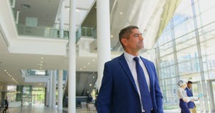 Kaukaski biznesmena odprowadzenie w lobby przy biurem 4k zbiory Kaukaski biznesmena odprowadzenie w lobby przy biurem 4k zbiory