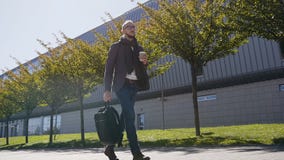Kaukaski urzędnik trzyma torby pić kawowy w ranku przed pracą blisko biura w kostiumu z szalikiem zdjęcie wideo Kaukaski urzędnik trzyma torby pić kawowy w ranku przed pracą blisko biura w kostiumu z szalikiem zdjęcie wideo
