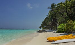 Kayak sur la plage kayaks à la belle plage tropicale avec des palmiers, sable blanc, l'eau d'océan de turquoise aux îles de Thina Photo libre de droits Kayak sur la plage kayaks à la belle plage tropicale avec des palmiers, sable blanc, l'eau d'océan de turquoise aux îles de Thina Photo libre de droits