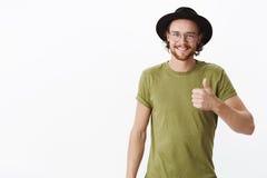 Keep up you doing great. Portrait of proud and satisfied charismatic young male with beard and pierced nose in glasses royalty free stock photos Keep up you doing great. Portrait of proud and satisfied charismatic young male with beard and pierced nose in glasses royalty free stock photos