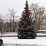 Kerstboom in de straat met rode ballen wordt verfraaid die en giftboxes royalty-vrije stock fotografie Kerstboom in de straat met rode ballen wordt verfraaid die en giftboxes royalty-vrije stock fotografie