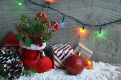Kerstmisdecoratie: rode Kerstman` s laars, spar, slinger, giften, denneappel en Kerstmisballen op houten achtergrond Kerstmisback Royalty-vrije Stock Afbeelding Kerstmisdecoratie: rode Kerstman` s laars, spar, slinger, giften, denneappel en Kerstmisballen op houten achtergrond Kerstmisback Royalty-vrije Stock Afbeelding
