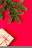 Kerstmissamenstelling op rode achtergrond Groene sparrentak en huidige doos royalty-vrije stock fotografie Kerstmissamenstelling op rode achtergrond Groene sparrentak en huidige doos royalty-vrije stock fotografie