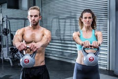 Kettlebells de levage d'un couple musculaire images stock Kettlebells de levage d'un couple musculaire images stock