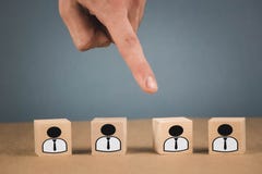 Keus van een werknemersleider van de menigte de handpunten aan de houten kubus die symboliseert dat de hand de keus maakt stock afbeeldingen Keus van een werknemersleider van de menigte de handpunten aan de houten kubus die symboliseert dat de hand de keus maakt stock afbeeldingen