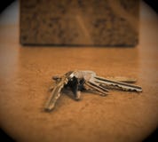 A key chain with several keys is lying on a apartment floor in front of a cardboard box. stock photo A key chain with several keys is lying on a apartment floor in front of a cardboard box. stock photo