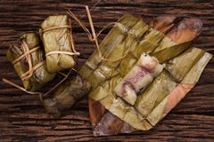 Khao Tom Mat - thailändsk efterrätt - klibbiga ris, bananen och svarta bönor som slås in i banan, spricker ut fotografering för bildbyråer Khao Tom Mat - thailändsk efterrätt - klibbiga ris, bananen och svarta bönor som slås in i banan, spricker ut fotografering för bildbyråer