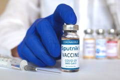 Kharkov, Ukraine - April 19, 2021: Sputnik V vaccine glass bottle in hand, doctor with vaccine vial against coronavirus