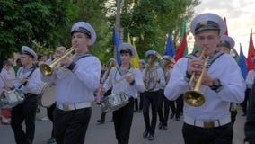 Sailors play musical instruments and carry colored flags on the street during the parade stock footage Sailors play musical instruments and carry colored flags on the street during the parade stock footage