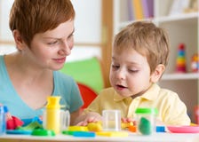 Kid boy with teacher play clay at home, kindergarten, daycare center or playschool royalty free stock images Kid boy with teacher play clay at home, kindergarten, daycare center or playschool royalty free stock images