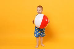 Kid boy 3-4 years old in blue beach summer clothes hold inflatable ball isolated on bright yellow orange wall background royalty free stock image Kid boy 3-4 years old in blue beach summer clothes hold inflatable ball isolated on bright yellow orange wall background royalty free stock image