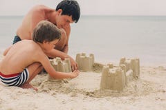Kid and his father building sandcastle royalty free stock photos Kid and his father building sandcastle royalty free stock photos