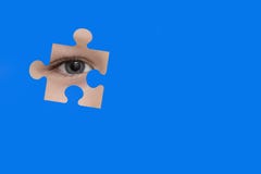 Kid spies through a blue puzzle. Symbol of autism awareness stock photos Kid spies through a blue puzzle. Symbol of autism awareness stock photos