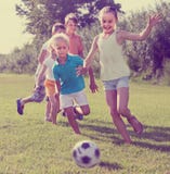 Kids kicking football in park Stock Images Kids kicking football in park Stock Images