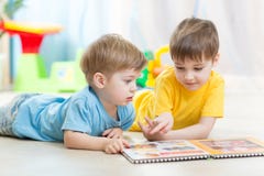 Kids looking at book in playschool or nursery stock photography Kids looking at book in playschool or nursery stock photography