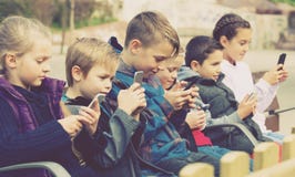 Kids Sitting With Mobile Devices Outdoor Stock Images Kids Sitting With Mobile Devices Outdoor Stock Images