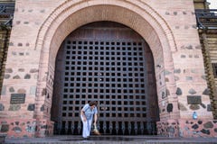 KIEV, UCRÂNIA - 8 DE AGOSTO DE 2015: Mulher adulta que cancela o trajeto na frente da entrada ao Golden Gate de Kiev, um dos monu fotos de stock KIEV, UCRÂNIA - 8 DE AGOSTO DE 2015: Mulher adulta que cancela o trajeto na frente da entrada ao Golden Gate de Kiev, um dos monu fotos de stock