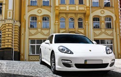Kiew, Ukraine, am 25. Juni 2015; Weißes Porsche Porsche Panamera auf dem Hintergrund von schönen Gebäuden lizenzfreie stockbilder Kiew, Ukraine, am 25. Juni 2015; Weißes Porsche Porsche Panamera auf dem Hintergrund von schönen Gebäuden lizenzfreie stockbilder