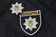 KIJÓW UKRAINA, LISTOPAD, - 22, 2016 Łata i odznaka policja narodowa Ukraina na czerni mundurujemy tło obraz stock KIJÓW UKRAINA, LISTOPAD, - 22, 2016 Łata i odznaka policja narodowa Ukraina na czerni mundurujemy tło obraz stock