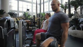 Kilka sportspeople pociągi ich nogi obsiadanie przed prasową maszyną w gym zbiory wideo Kilka sportspeople pociągi ich nogi obsiadanie przed prasową maszyną w gym zbiory wideo