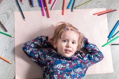 Kind die op het vloerdocument dichtbij kleurpotloden liggen Meisje het schilderen, het trekken Hoogste mening Het concept van de stock foto's Kind die op het vloerdocument dichtbij kleurpotloden liggen Meisje het schilderen, het trekken Hoogste mening Het concept van de stock foto's