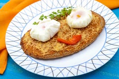 Kinderen` s menu: hete sandwich van zwart roggebrood met geraspte kaas en een gestroopt ei op een plaat op een blauwe houten acht Stock Afbeeldingen Kinderen` s menu: hete sandwich van zwart roggebrood met geraspte kaas en een gestroopt ei op een plaat op een blauwe houten acht Stock Afbeeldingen