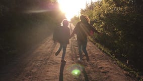 Kinderenreizigers Wandelaarmeisje de gelukkige die meisjesreizigers met rugzakken langs landwegholding in werking worden gesteld stock videobeelden Kinderenreizigers Wandelaarmeisje de gelukkige die meisjesreizigers met rugzakken langs landwegholding in werking worden gesteld stock videobeelden