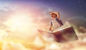 Kinderfliegen auf dem Buch lizenzfreie stockfotos Kinderfliegen auf dem Buch lizenzfreie stockfotos
