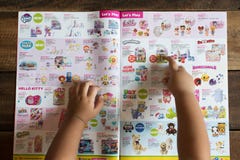Kinderhand, die auf ihr Traumspielzeug auf einer Broschüre der SPIELWAREN ‚R ‚US zeigt stockfoto Kinderhand, die auf ihr Traumspielzeug auf einer Broschüre der SPIELWAREN ‚R ‚US zeigt stockfoto