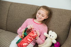 Kindermädchen, das in der Hand ein Geschenk hält und rote Geschenkbox öffnet lizenzfreie stockbilder Kindermädchen, das in der Hand ein Geschenk hält und rote Geschenkbox öffnet lizenzfreie stockbilder
