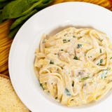 Kippenfettuccine Alfredo met spinazie stock afbeelding Kippenfettuccine Alfredo met spinazie stock afbeelding