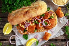 Kippensandwich met mosterdsaus en rood ui verfrommeld document stock afbeelding Kippensandwich met mosterdsaus en rood ui verfrommeld document stock afbeelding