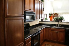 Kitchen wood cabinets black and stainless stove
