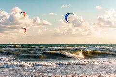 Kitesurfers ride kites through surfing waves of stormy sea at Blaga Beach resort at sunset Royalty Free Stock Photos Kitesurfers ride kites through surfing waves of stormy sea at Blaga Beach resort at sunset Royalty Free Stock Photos