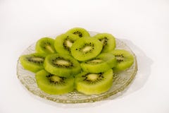 Kiwi savoureux vert juteux frais du plat en cristal avec le fond blanc images libres de droits Kiwi savoureux vert juteux frais du plat en cristal avec le fond blanc images libres de droits