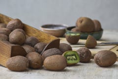 Kiwis et tranches de kiwi dans une boîte en bois et une cuvette photo stock Kiwis et tranches de kiwi dans une boîte en bois et une cuvette photo stock