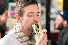 Klant die Hotdog in snel voedselsnackbar eten stock fotografie Klant die Hotdog in snel voedselsnackbar eten stock fotografie