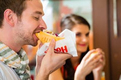 Klanten die Hotdog in snel voedselsnackbar eten stock afbeeldingen Klanten die Hotdog in snel voedselsnackbar eten stock afbeeldingen