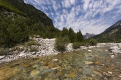Klar bergflod Theth i den Theth nationalparken, Shkodra region, Albanien royaltyfri foto Klar bergflod Theth i den Theth nationalparken, Shkodra region, Albanien royaltyfri foto