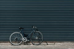 Klassieke hipsterfiets die dichtbij zwarte muur zich in openlucht bevinden royalty-vrije stock foto Klassieke hipsterfiets die dichtbij zwarte muur zich in openlucht bevinden royalty-vrije stock foto