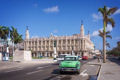 Klassisches amerikanisches Auto auf Paseo Del Prado, Gran-theatro De-La Havana im Hintergrund lizenzfreies stockbild Klassisches amerikanisches Auto auf Paseo Del Prado, Gran-theatro De-La Havana im Hintergrund lizenzfreies stockbild