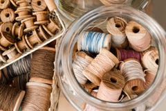 Kleine houten rollen in een mand en grote rollen met kleurrijke draden in een glaskruik royalty-vrije stock afbeelding Kleine houten rollen in een mand en grote rollen met kleurrijke draden in een glaskruik royalty-vrije stock afbeelding