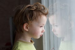 Kleine jongenszitting dichtbij venster en het denken over iets Hij heeft mooi groot haar Leuke baby stock foto's Kleine jongenszitting dichtbij venster en het denken over iets Hij heeft mooi groot haar Leuke baby stock foto's