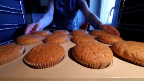 Kleine Kuchen zu Hause kochen Schönes Mädchen in der Küche entfernen Muffins vom Ofen stock footage Kleine Kuchen zu Hause kochen Schönes Mädchen in der Küche entfernen Muffins vom Ofen stock footage