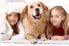 Kleine Schwestern und lächelnder Haustierhund zu Hause lizenzfreie stockbilder Kleine Schwestern und lächelnder Haustierhund zu Hause lizenzfreie stockbilder