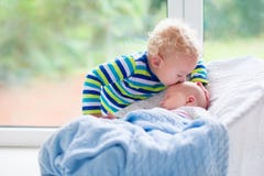 Kleiner Junge, der neugeborenen Babybruder küsst stockfotografie Kleiner Junge, der neugeborenen Babybruder küsst stockfotografie